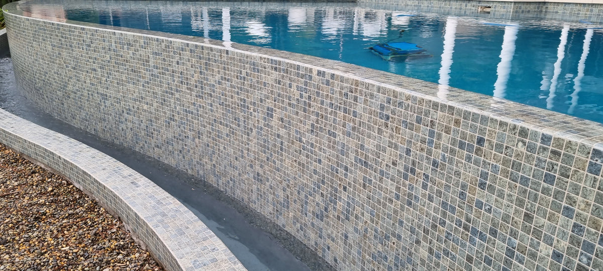 Glass mosaic waterline below pool coping