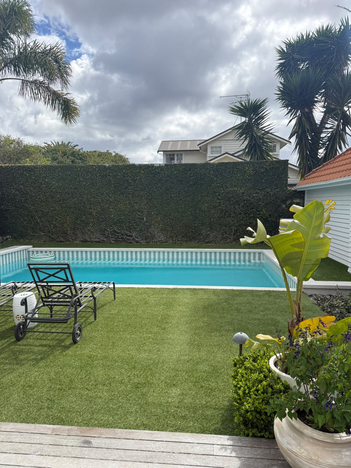 Ultra Quartz Aquamarine pool plaster in a finished Auckland backyard pool with striped glass mosaic waterline