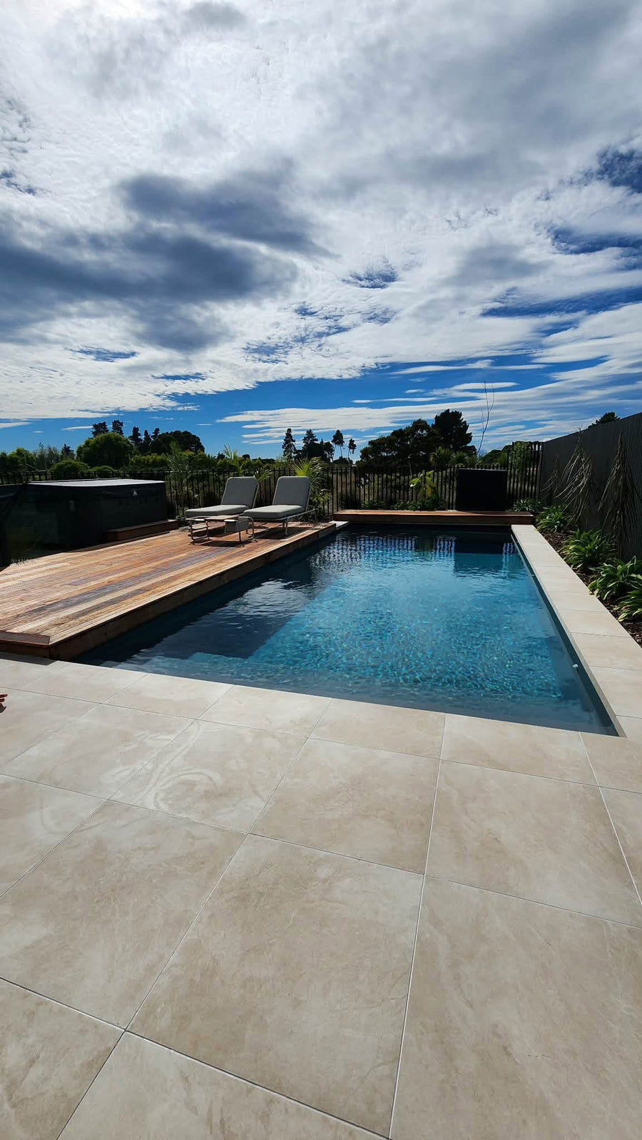Rectangular pool with timber deck, porcelain paving and coping, Auckland