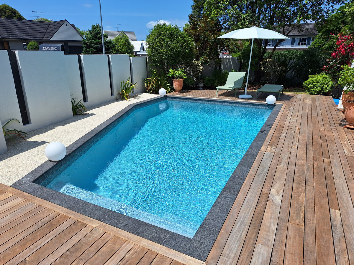 Black granite bullnose coping around a garden pool with timber decking