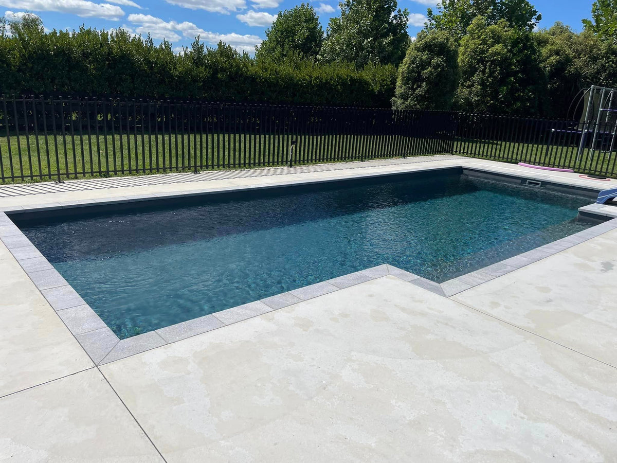 Fantasy granite square edge coping framing a dark pool