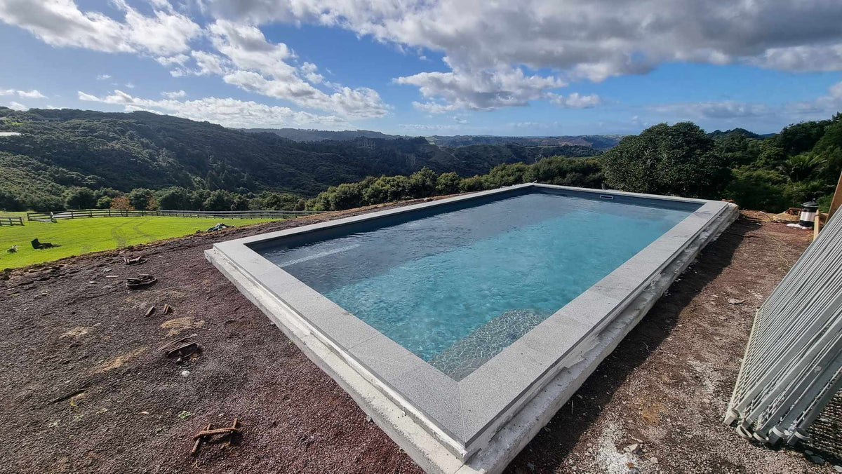 Flamed grey granite square edge coping on a raised pool with rural views
