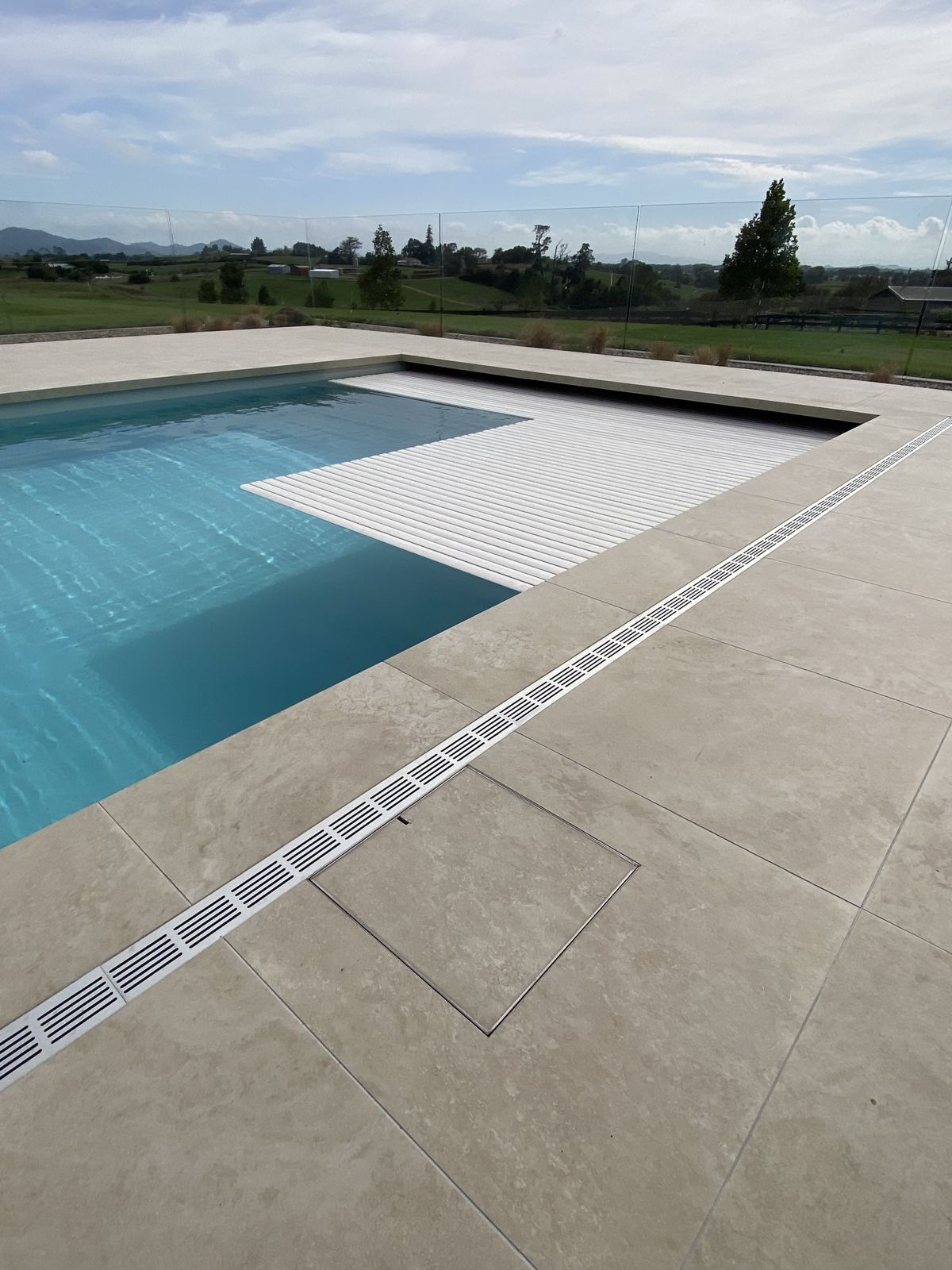 Ultra Drain Plus with slotted alloy top running beside a pool in large format pavers